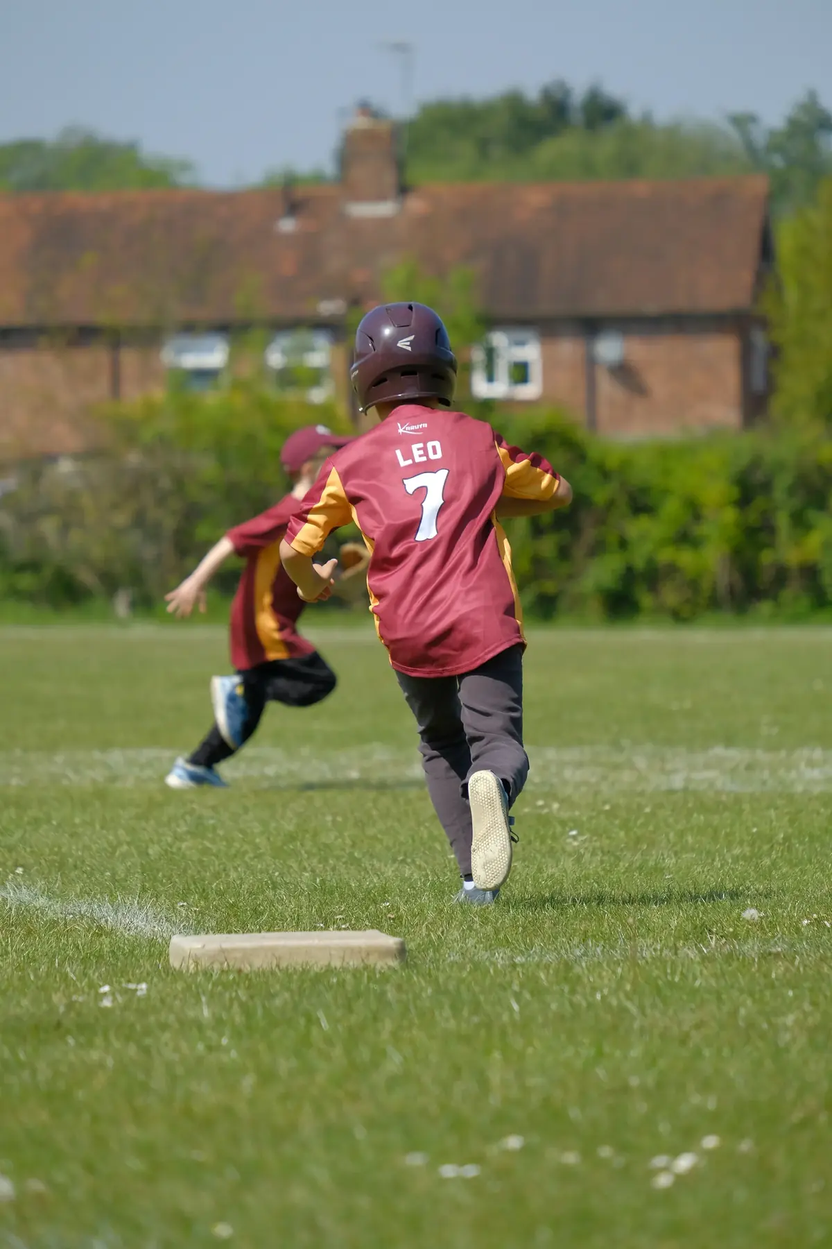 A junior player in the Guildford jersey, number 7, running the bases